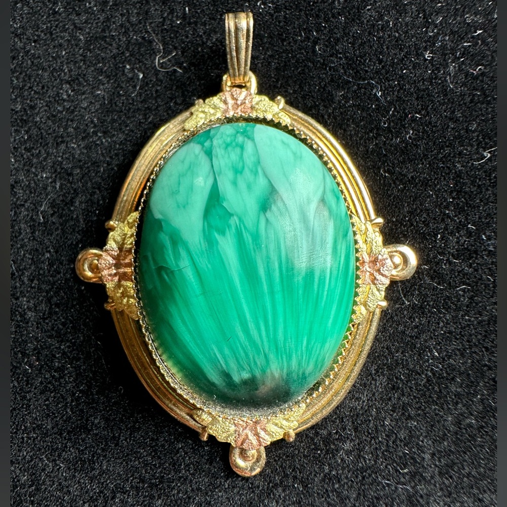 Green stone pendant with rose-gold leaf accents and gold tone setting.
